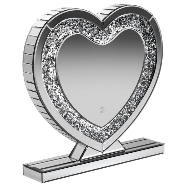 This heart-shaped table mirror blends glam style with practical lighting, perfect for vanities or dressing areas. The mirrored frame features an inset of faceted acrylic crystal inlay that catches light beautifully, while integrated LED illumination adds 