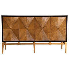 Bold texture and dynamic form converge in this four-door accent cabinet featuring a hand-applied sunburst motif. The intricate radial design is crafted with layered wood strips, framed in a rich brown outline and contrasted by a golden base. Angled, taper