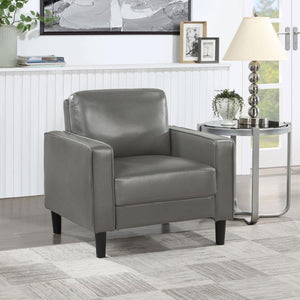  this modern armchair is a chic choice. It features a structured silhouette with a compact footprint and straight track arms. Faux leather upholstery is smooth and sleek