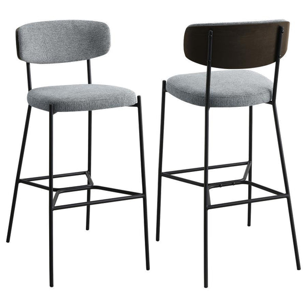 Create a relaxed and inviting ambiance at a kitchen bar or in your home lounge with a set of two modern barstools. Each boasts a durable and strong metal frame with a sandy black finish. Dark oak finish backrests complement neutral upholstery, offering fo