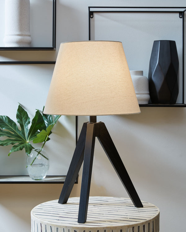 This table lamp-'s unique wooden tripod base is beautifully complemented by an empire hardback shade. The perfect touch for mid-century modern or upscale urban rooms, this piece is sure to add an artistic touch wherever it-'s displayed.<br><br><b>Addition