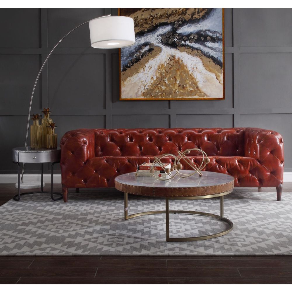 Enhance the modern vibe of your living room with the Tamas round coffee table. Its slender metal base is artfully curved to add style, and the aluminum patchwork table top provides a durable surface for piping hot or ice-cold beverages. The apron is wrapp