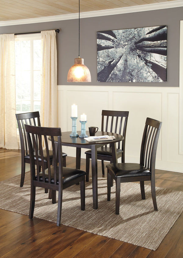 Made with select birch veneer and hardwood solids in a transitional dark brown finish with gray undertones. Compact table seats four and includes drop leaves for multi-function. <h4><b>Hammis - Dark Brown - Round DRM Drop Leaf Table</b></h4> <table width=
