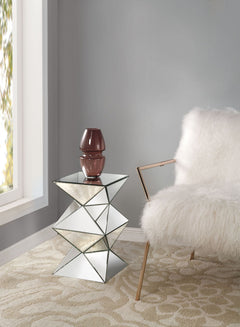 The gorgeous Nyoka mirrored pedestal stand is a great addition to your foyer or living room. This table is a sight with its rectangular mirror top with a unique geometric base that is a combination of regular mirror and black decorative crystal center. Un