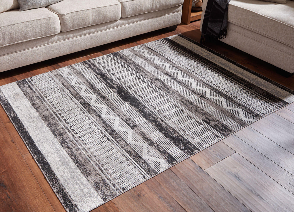 Drawing on tribal weaving motifs, this area rug features a repeating pattern with several unique markings. Its distressed design and neutral palette provide a distinctive look and feel for a variety of interiors, from contemporary to boho chic. Whether in