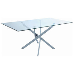 This rectangular dining table delivers sculptural impact with a crisp modern profile. Its clear tempered glass top offers a clean, durable surface that visually opens the space. Below, a striking asterisk-shaped base crafted from heavy gauge metal adds ar