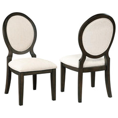 Elegant curves and contrasted finishes collide in this transitional side chair. A lovely addition to a dining space, this stunning chair can be slid up to a table for a comfortable place to sit over a long dinner, inviting you to lean back against its pad