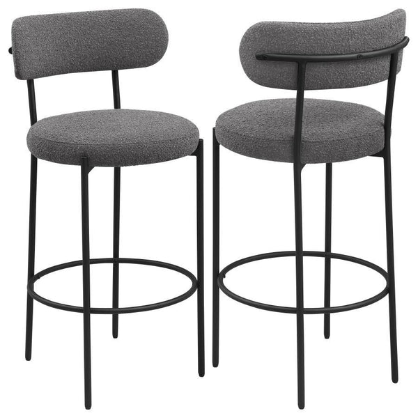 Refresh your kitchen island or elevated bar table with a set of two modern barstools. Each features foam cushions and contemporary boucle upholstery in a neutral hue. Black finish metal framing provides excellent support and durability, while slim legs an