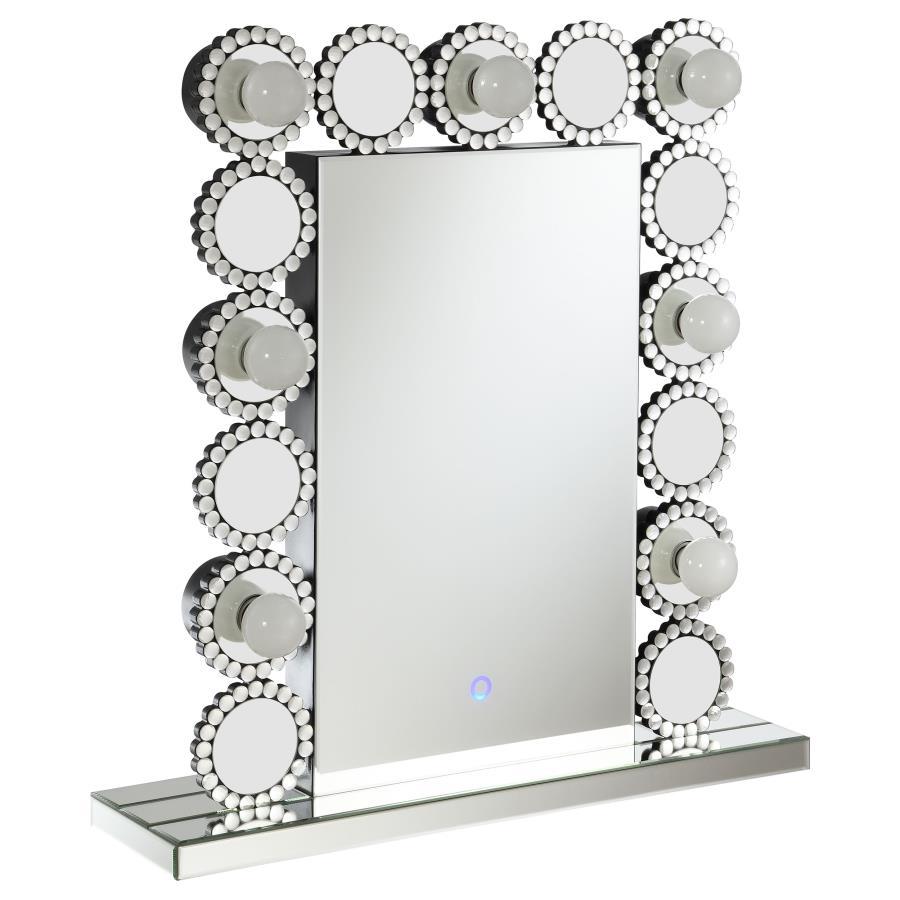 Rest this contemporary table mirror along a dresser or vanity surface for a playful, elegant aesthetic. Surrounded by seven LED bulbs that provide a soft, bright glow for perfecting your glow up, this table mirror offers a dramatic statement piece for bed