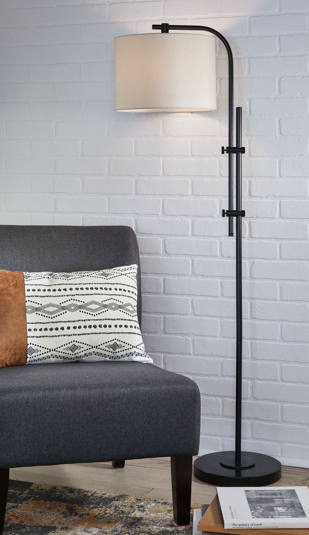 This floor lamp features a beautiful black finish that adds a striking accent to your living space. The lamp is elegantly curved with soft edges, and is adjustable to provide targeted illumination. Topped off with a crisp white drum shade, this lamp provi