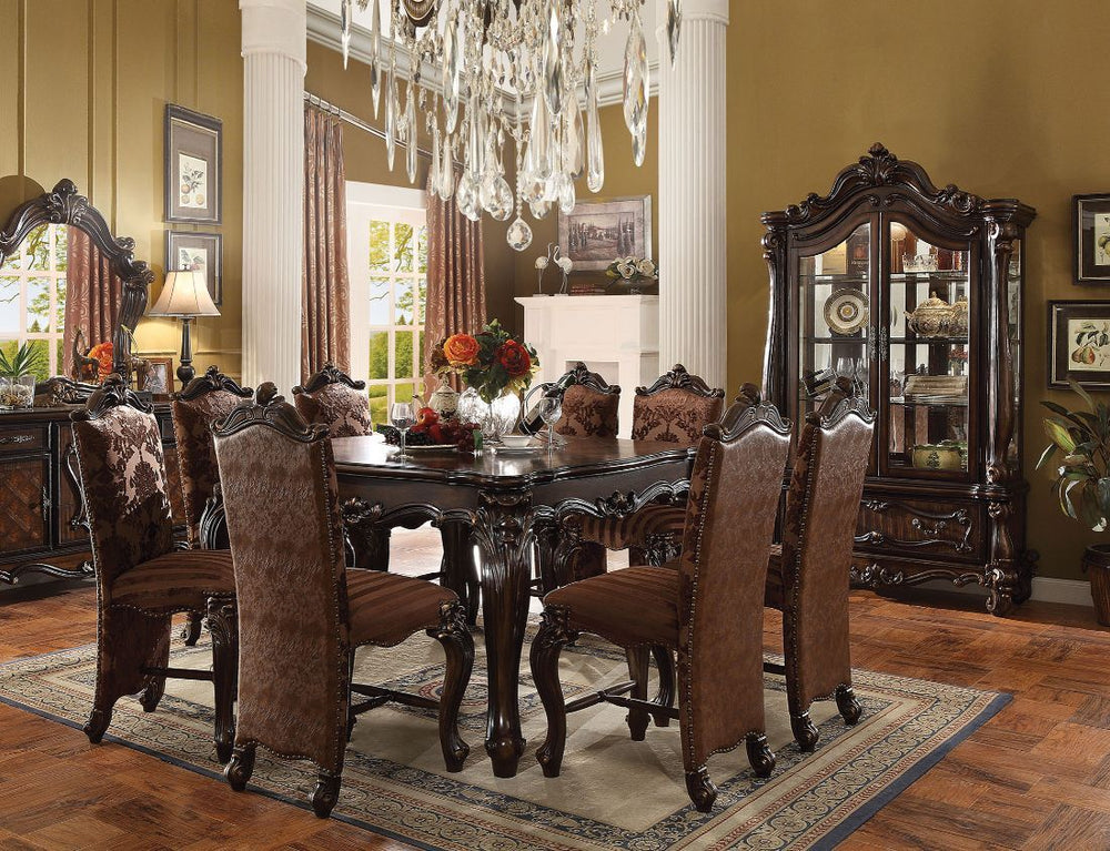 Irresistibly inviting, the Versailles collection displays the unrivaled beauty of the traditional dining. The dining table reflects highly decorative base with oversized scrolled feet, and the upholstered and tapestried chairs with the deep button tufted 