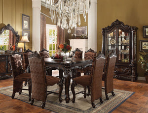 Irresistibly inviting, the Versailles collection displays the unrivaled beauty of the traditional dining. The dining table reflects highly decorative base with oversized scrolled feet, and the upholstered and tapestried chairs with the deep button tufted 