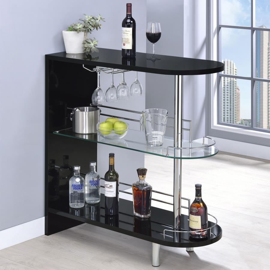 This stylish bar unit is a fabulous option for your entertaining needs. A sleek silhouette and glossy black finish give it a chic, modern appeal. Its tempered glass storage shelves offer a handy place to display a collection of fine wines and spirits. Pro