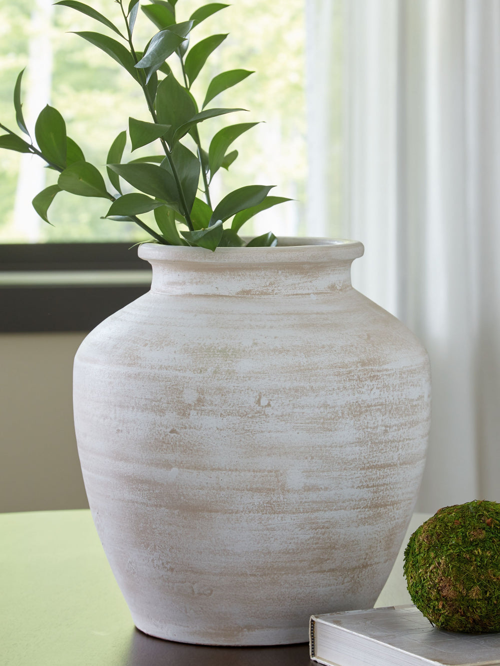 Celebrate the artisanal character of ceramics with this vase. Its distressed white finish has a time-worn, weathered appeal, offering the look of the past with a modern feel. The vase-'s neutral tone makes it a go-to for all seasons, allowing you to stage