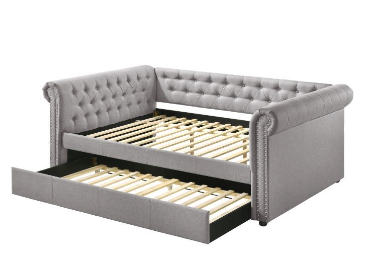 The fully upholstered daybed embodies a classic aesthetic infused with rich textures. This timeless piece features a chesterfield button-back design while smoky gray fabric upholstery makes you indulge in a luxurious comfort. An additional trundle underne