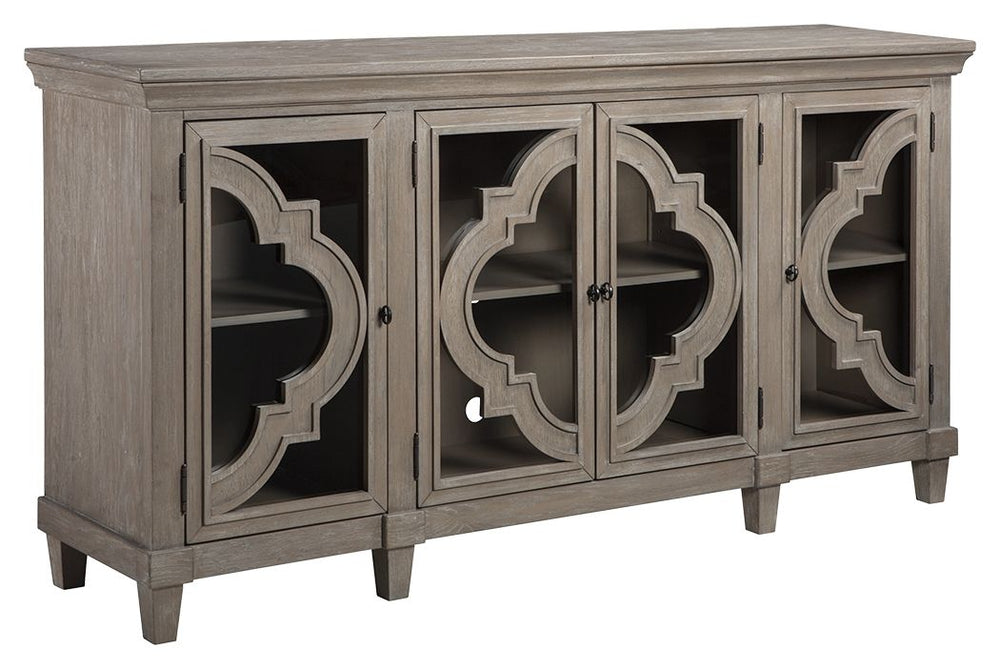 Wowing with exquisite quatrefoil framing, made all the more dramatic with the contrast of clear glass, this 4-door cabinet serves up an easy-elegant aesthetic sure to satisfy. The light and lovely finish brings a relaxed sensibility to the scene.<br><br><
