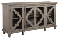 Wowing with exquisite quatrefoil framing, made all the more dramatic with the contrast of clear glass, this 4-door cabinet serves up an easy-elegant aesthetic sure to satisfy. The light and lovely finish brings a relaxed sensibility to the scene.<br><br><
