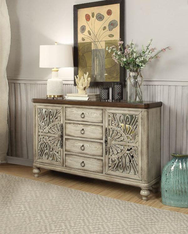 The elegant Vernon Console Table features an antique white finish with decorative cabinet door inlays. The rectangular wood console table features 4 center drawers and 2 doors on each end that reveal 4 additional shelves, providing ample display and addit