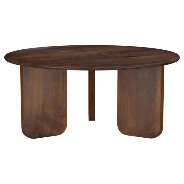 Embrace artistry and modern design with this round coffee table, crafted from solid mango wood. The rich brown finish highlights the natural wood grain, creating a warm and inviting centerpiece for your living room. A round tabletop with softly rounded ed