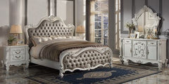 Turn your bedroom into a classy abode with this sophisticated Versailles II bed in a vintage gray PU and bone white finish. The curved wood trim on the headboard and footboard is accentuated with a fluted seashell motif crown. The deep button tufting adds