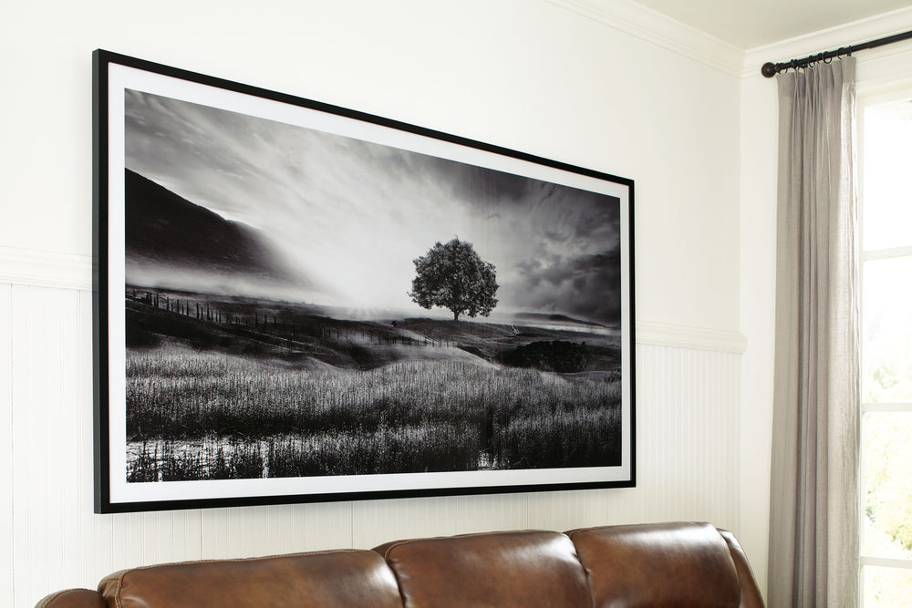 Filled with calming natural elements, this wall art has a refined look with a restful feel. It captures a landscape with rolling hills, drawing your eye to the tree standing tall in the center of the creation. Lighter tones in the clouds bring brightness 