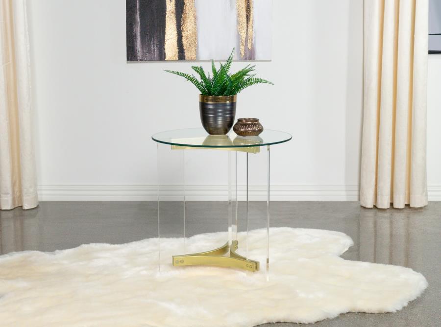 This elegant round end table features a clear tempered glass top and sturdy clear acrylic legs. The matte brass electroplated metal frame supports the piece with a touch of luxury. The minimalist design offers both style and function, making it a perfect 
