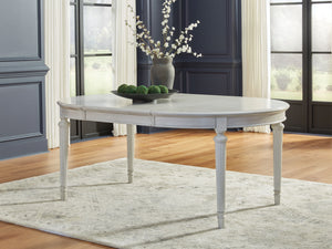  its classic antiqued white finish is paired with reeded legs and a tabletop with a butterfly-matched veneer pattern. With the removable center le