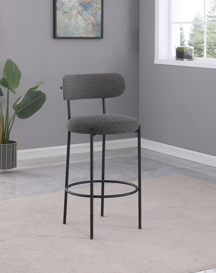Refresh your kitchen island or elevated bar table with a set of two modern barstools. Each features foam cushions and contemporary boucle upholstery in a neutral hue. Black finish metal framing provides excellent support and durability, while slim legs an