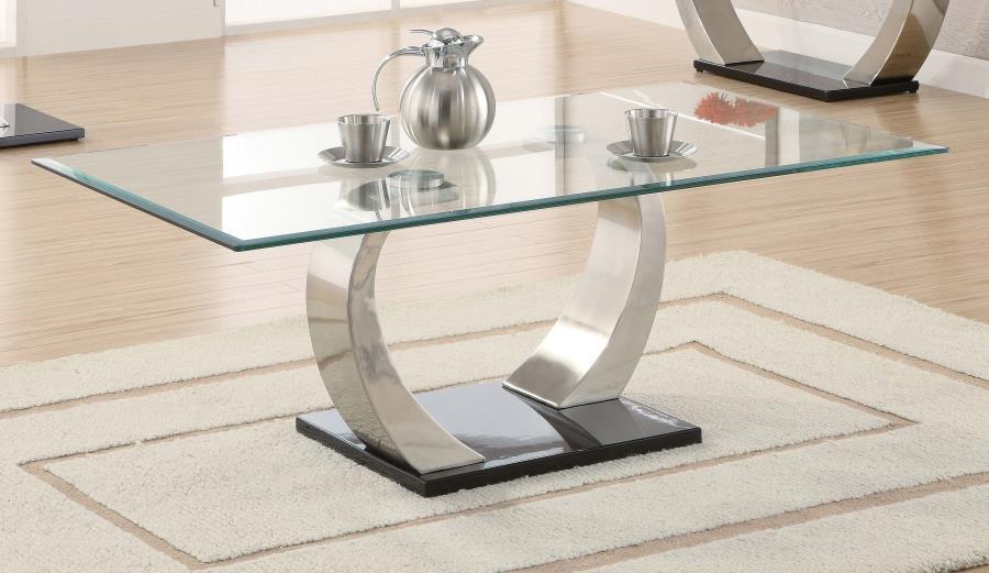 Elevate your living space with this modern coffee table, showcasing a tempered glass top for enhanced durability and style. The dual curved bases feature a brushed satin silver finish, adding sleek contemporary appeal, while the polished black platform ba