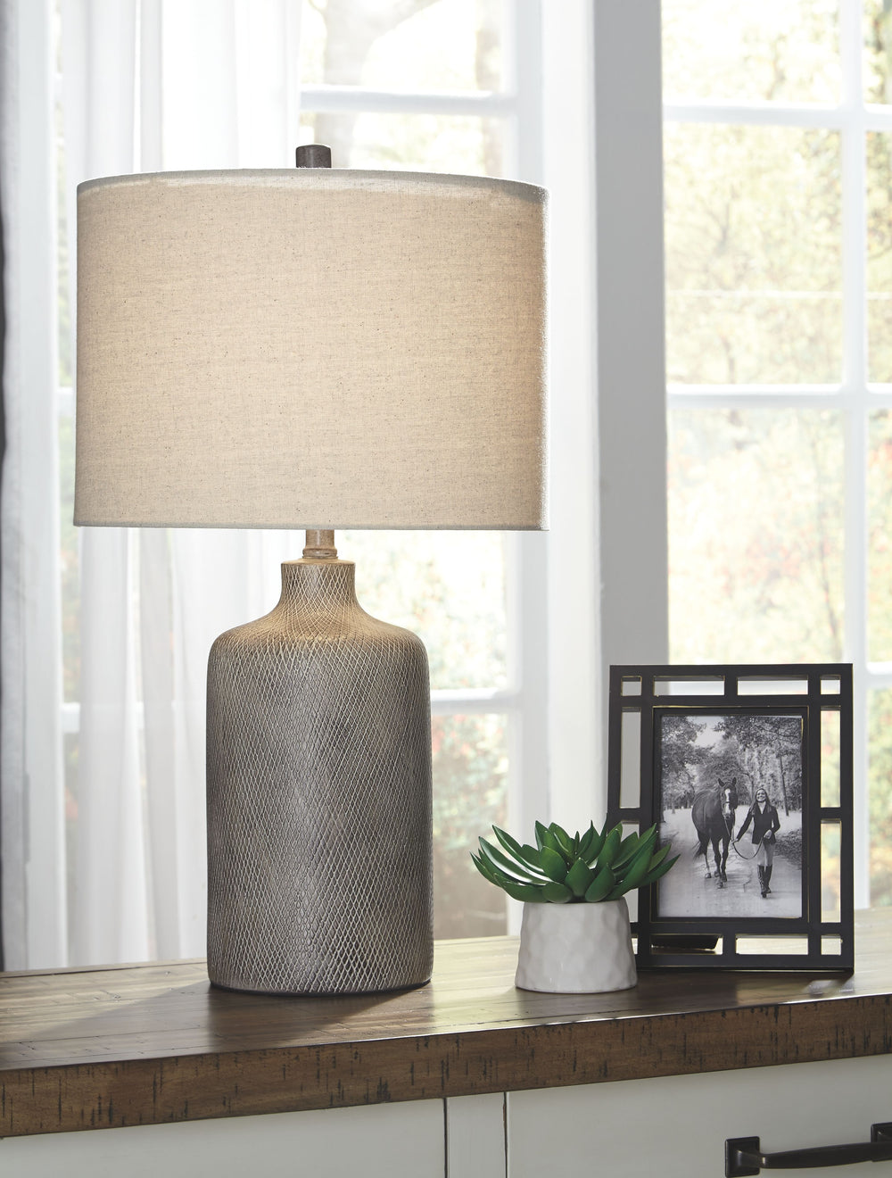 Brighten your bedside or illuminate your living space with this stylish table lamp. Understated ceramic base is finished with a striking antique black effect. Fabric drum shade is a soft touch and harbors light wonderfully.<br><br><b>Additional Dimensions
