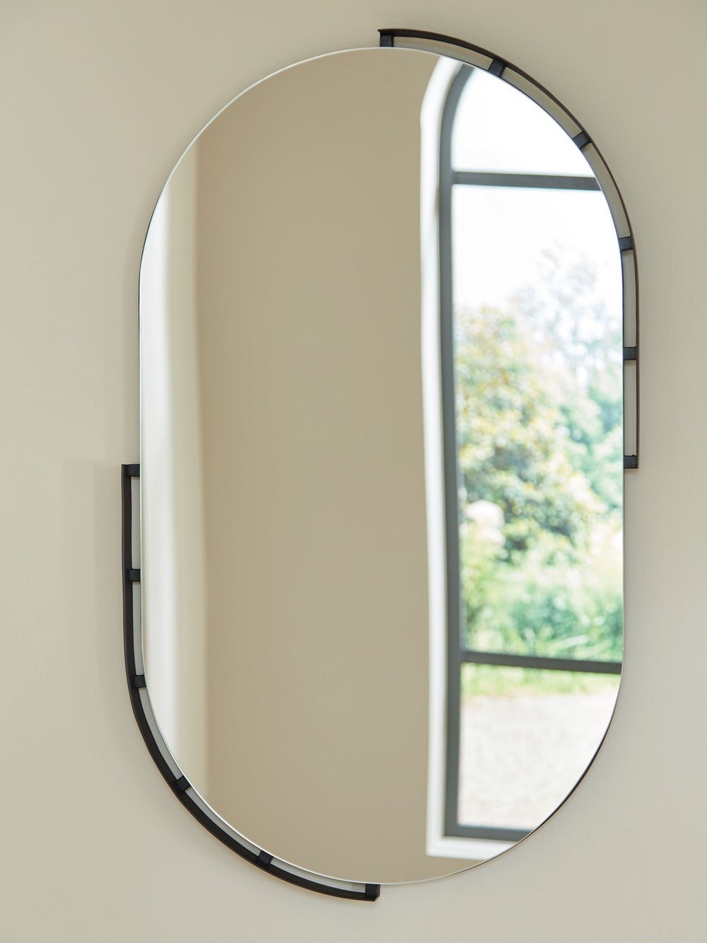 Update your home or office with contemporary appeal. This accent mirror is subtly embellished, with black metal accents bordering its striking oval shape. Make a statement, curate a quirky collection, or use it to make your space appear largerâ€”the desig