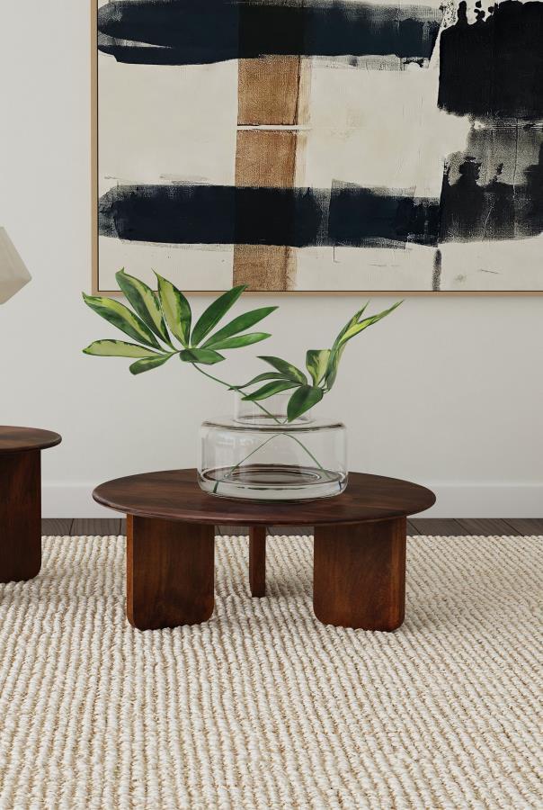 Embrace artistry and modern design with this round coffee table, crafted from solid mango wood. The rich brown finish highlights the natural wood grain, creating a warm and inviting centerpiece for your living room. A round tabletop with softly rounded ed