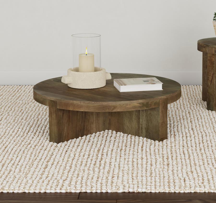 Center your living space around the striking, solid profile of a modern wooden coffee table. Crafted in exquisite mango wood, the table receives a dark brown finish to ensure standout style. The round cocktail table is a low, inviting centerpiece for your