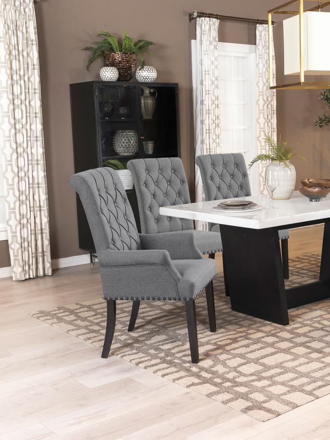 Designed for both luxury and support, this arm chair brings an elegant presence to any dining space. Its button-tufted high back and rolled top lend a timeless aesthetic, while the addition of padded armrests enhances comfort. Hand-applied nailhead trim o