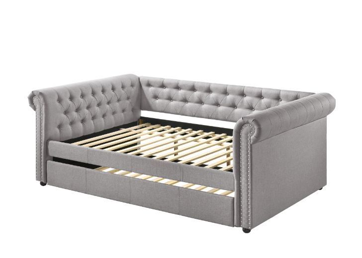The fully upholstered daybed embodies a classic aesthetic infused with rich textures. This timeless piece features a chesterfield button-back design while smoky gray fabric upholstery makes you indulge in a luxurious comfort. An additional trundle underne