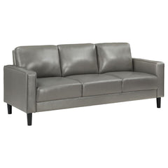 Establish the foundation of a stylish living room with a modern sofa. Smooth faux leather creates a sleek, neutral look that brims with sophistication. Track arms create a structured silhouette, offering tailored flair with an understated ambiance. Straig