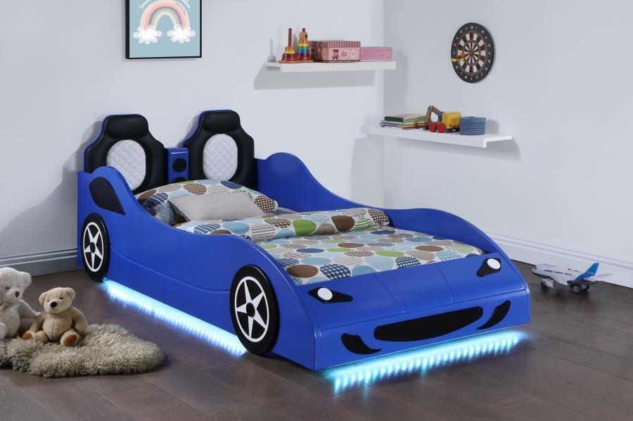 Modern race car aesthetics inform the design of a novelty car bed perfect for kids. Its twin size is versatile, allowing for plenty of space to play within the bedroom. The car is complete with realistic details and features LED strip lighting underneath,