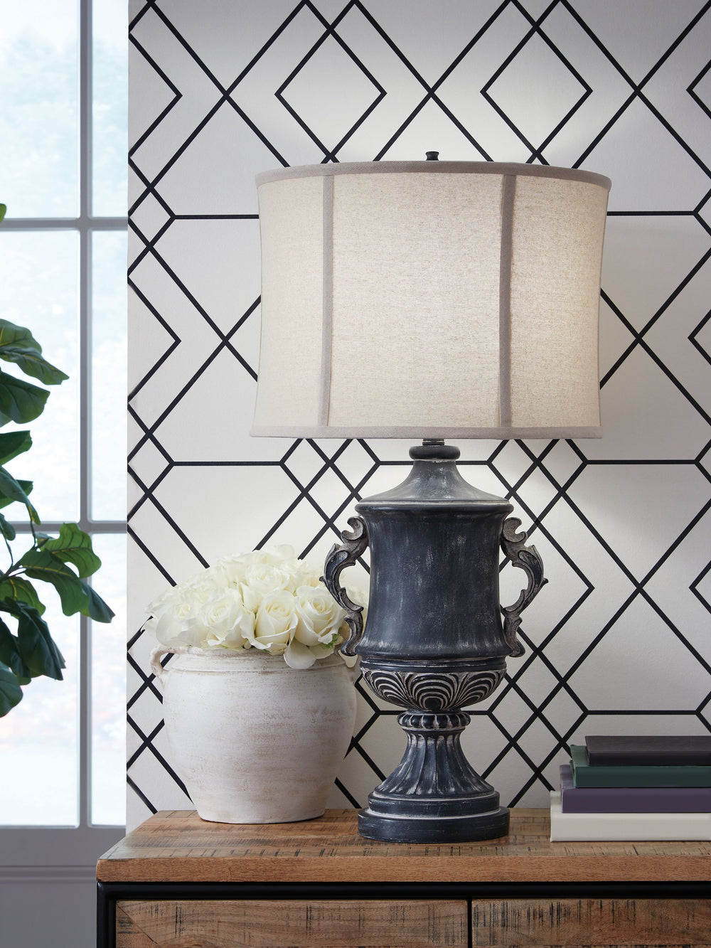 Those who delight in the beauty of a bygone era are sure to be charmed by this richly traditional table lamp. Its base is detailed with ornate patterns and embellished with gracefully curved handles. An antiqued black finish lends a look thatâ€™s aged to 