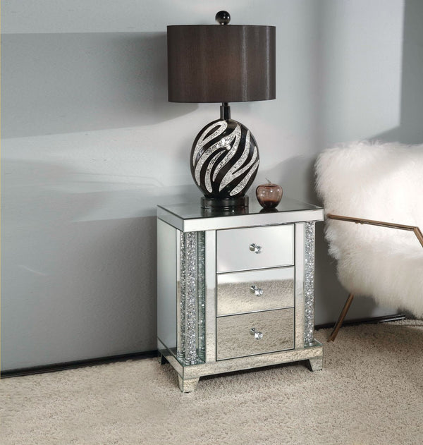The Noralie mirrored occasional table demonstrates sophisticated, graceful and elegant, style with unique design. This table features three storage drawers decorative drawer pull knobs. While elegantly reflecting its surroundings, combines glamour with mo