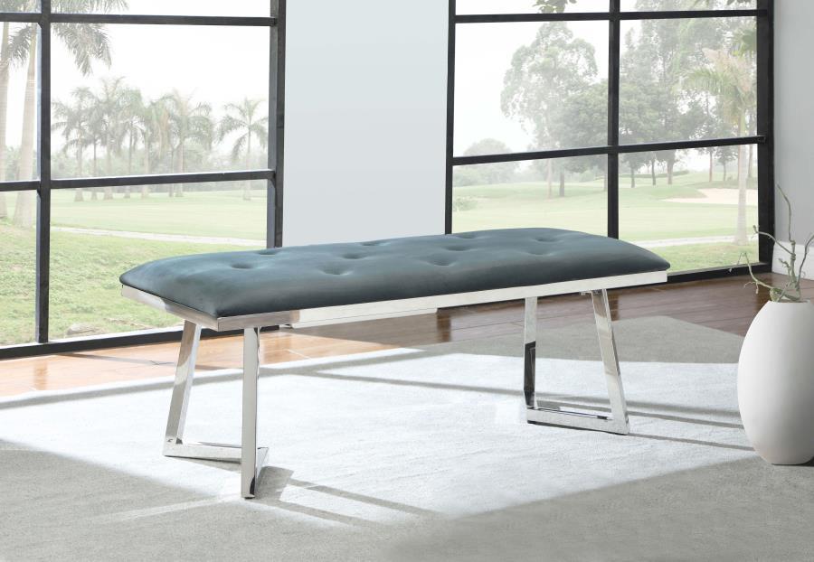 Add a sophisticated edge to your dining space with this contemporary velvet dining bench. Upholstered in plush grey velvet with button tufting, it offers a soft and inviting seat. The polished stainless steel base boasts a striking angular frame, deliveri