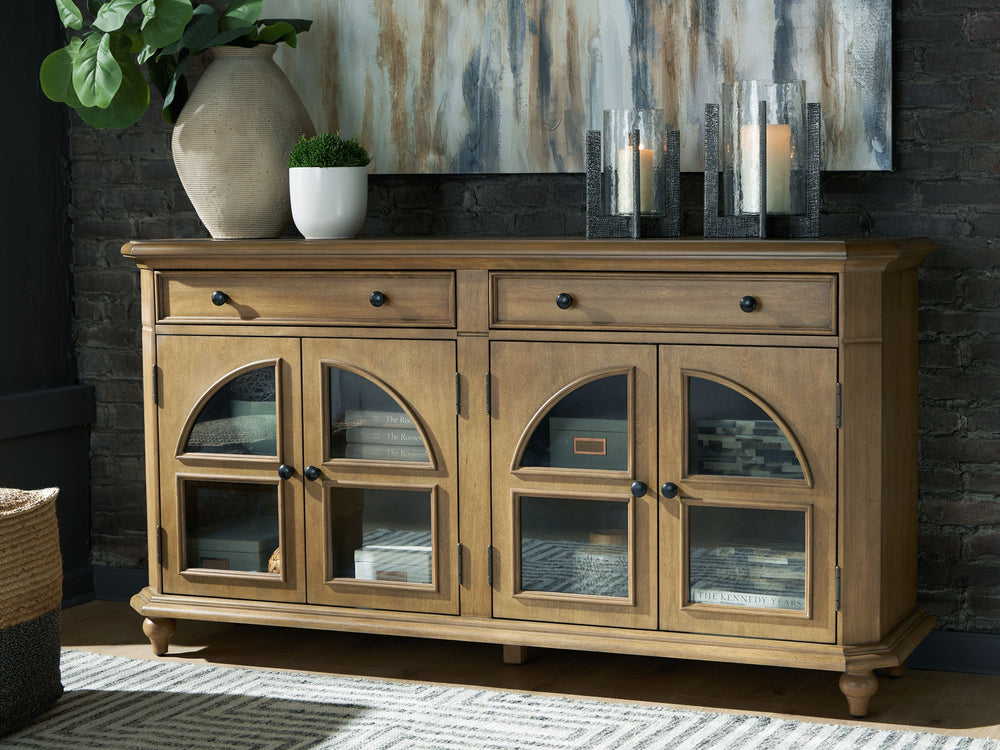This lovely accent cabinet is a masterful blend of classic charm and practicality. A light brown finish and arched glass panel doors create a timeless look, while the spacious drawers and adjustable shelves offer versatile storage options. Convenient open