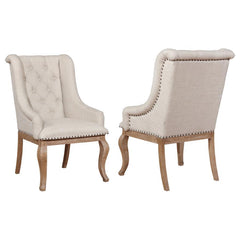 Gracefully swooping arms create an engaging silhouette for this dining armchair. Beautiful in a refined space, the chair boasts diamond button tufting across its back, with a comfortably cushioned and smoothly upholstered seat. Rolled arms complete a comp