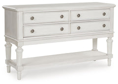 Transform your home into a haven of timeless elegance with this dining server. It pairs a classic antiqued white finish with reeded legs for traditional styling. Four drawers with fully finished interiors offer spacious storage for essentials. The large s
