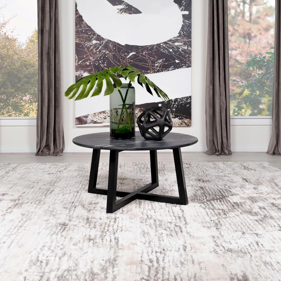 The coffee table stands as a centerpiece, its round form a canvas for the rich, decorative black faux marble that offers the beauty of natural stone with none of its fragility. The high-pressure laminate surface is a triumph of design, melding high durabi