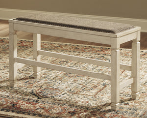  this generously scaled counter-height bench entices with a cushioned seat covered in a heavy woven fabric that complements the antiqued white finish.<br><br><