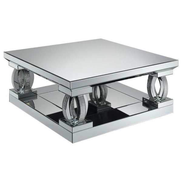 This 40-inch square coffee table brings bold, contemporary style to your living space. With its mirrored surfaces and sturdy construction, it features a large, symmetrical top and matching base for visual balance. Sculptural, oval-shaped supports adorned 