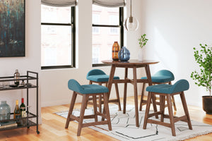 This counter-height dining set is a refreshed take on retro aesthetics. The counter table adds an air of playful simplicity to your dining space and the upholstered bar stool invites the eye with a soft-edged silhouette cushion. This set captures the arch