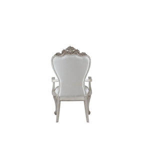  decorated with raised and scrolled floral motifs in an antique champagne finish. This unique chair is upholstered in a cream fab