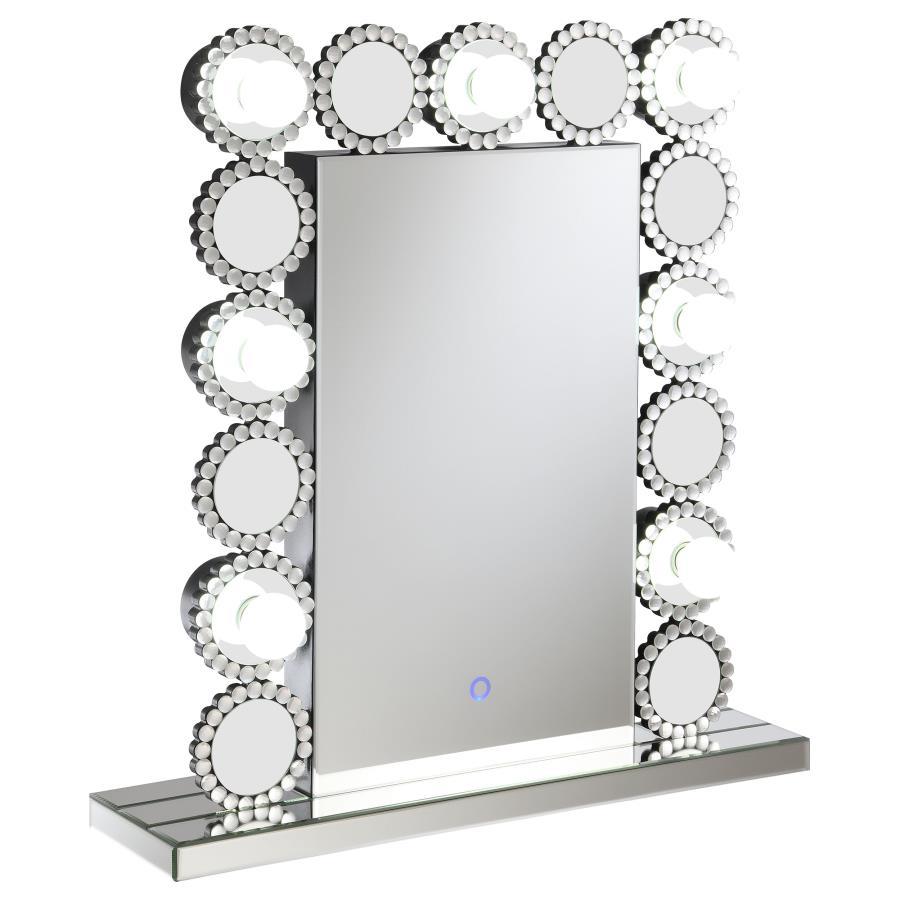 Rest this contemporary table mirror along a dresser or vanity surface for a playful, elegant aesthetic. Surrounded by seven LED bulbs that provide a soft, bright glow for perfecting your glow up, this table mirror offers a dramatic statement piece for bed