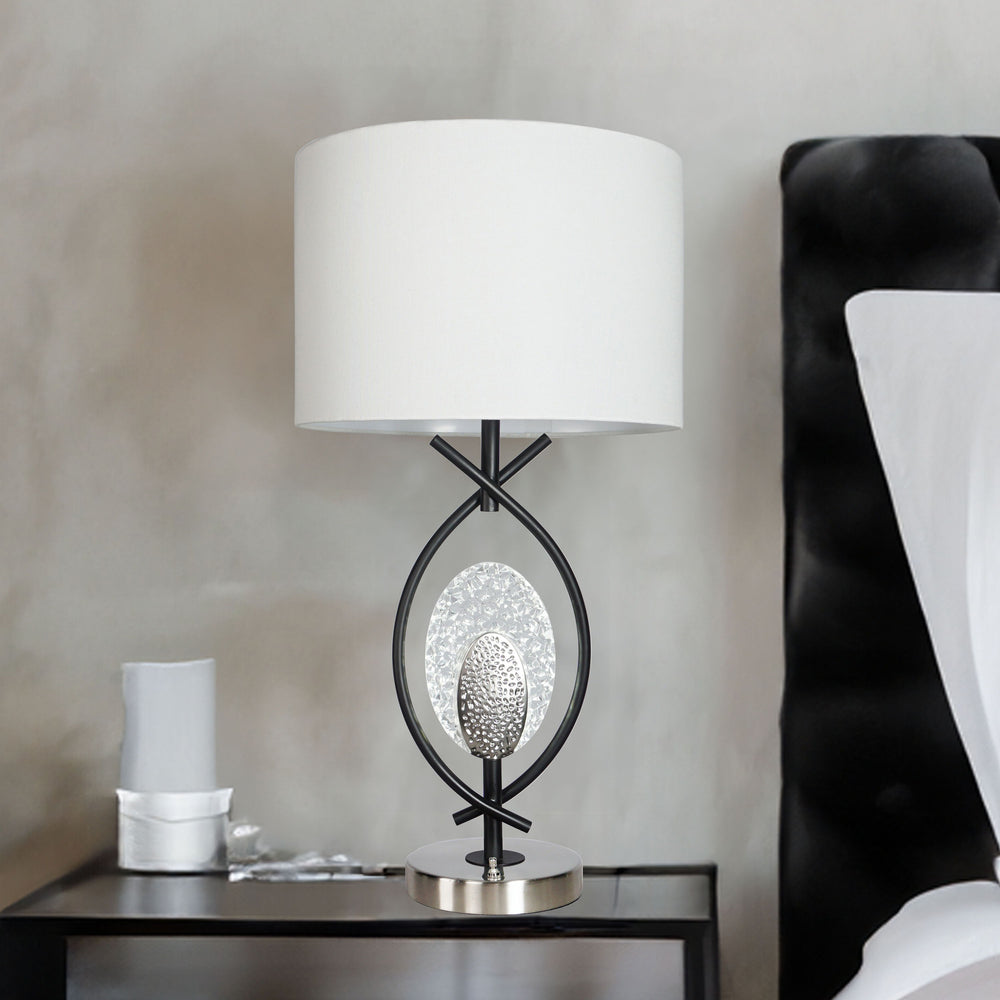 Elevate your decor with a striking combination of modern artistry and functional elegance. This exquisite table lamp showcases a unique intertwining metal frame that exudes sophistication and visual intrigue. At its heart, a sparkling crystal accent and t
